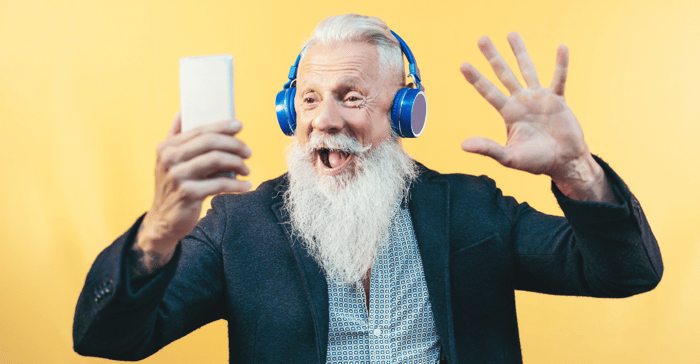 Smiling white man with grey beard taking a OneID selfie with yellow background