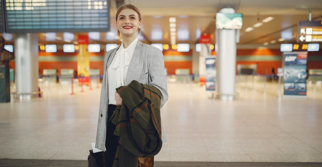 Smiling business woman in airport travelling for remote job
